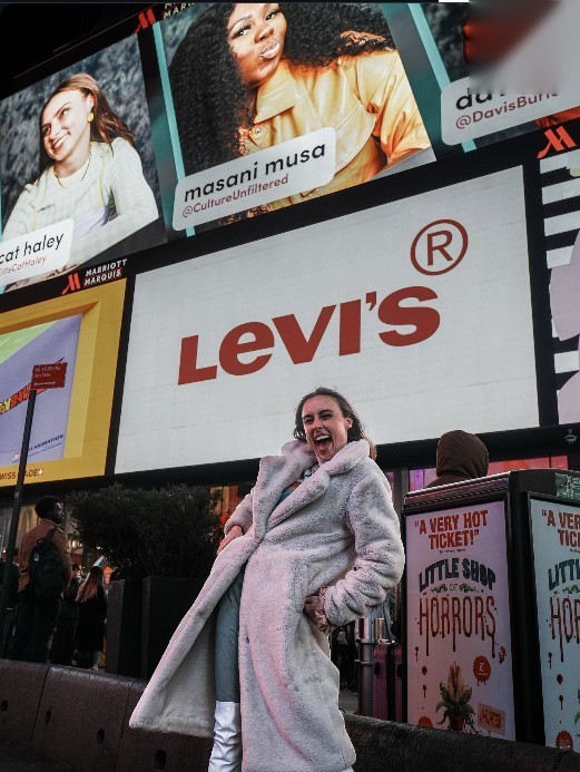 Cat Haley beneath her Times Square campaign billboard